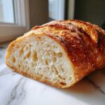 Cross-section view showing the airy, open crumb structure of the freshly baked french bread.