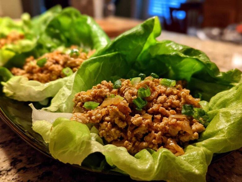 Close-up of delicious chicken lettuce wraps filled with savory ground chicken and topped with green onions.