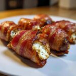 Close-up of crispy bacon wrapped stuffed dates filled with creamy cheese mixture.
