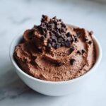 A close-up of creamy chocolate overnight oats topped generously with mini chocolate chips.