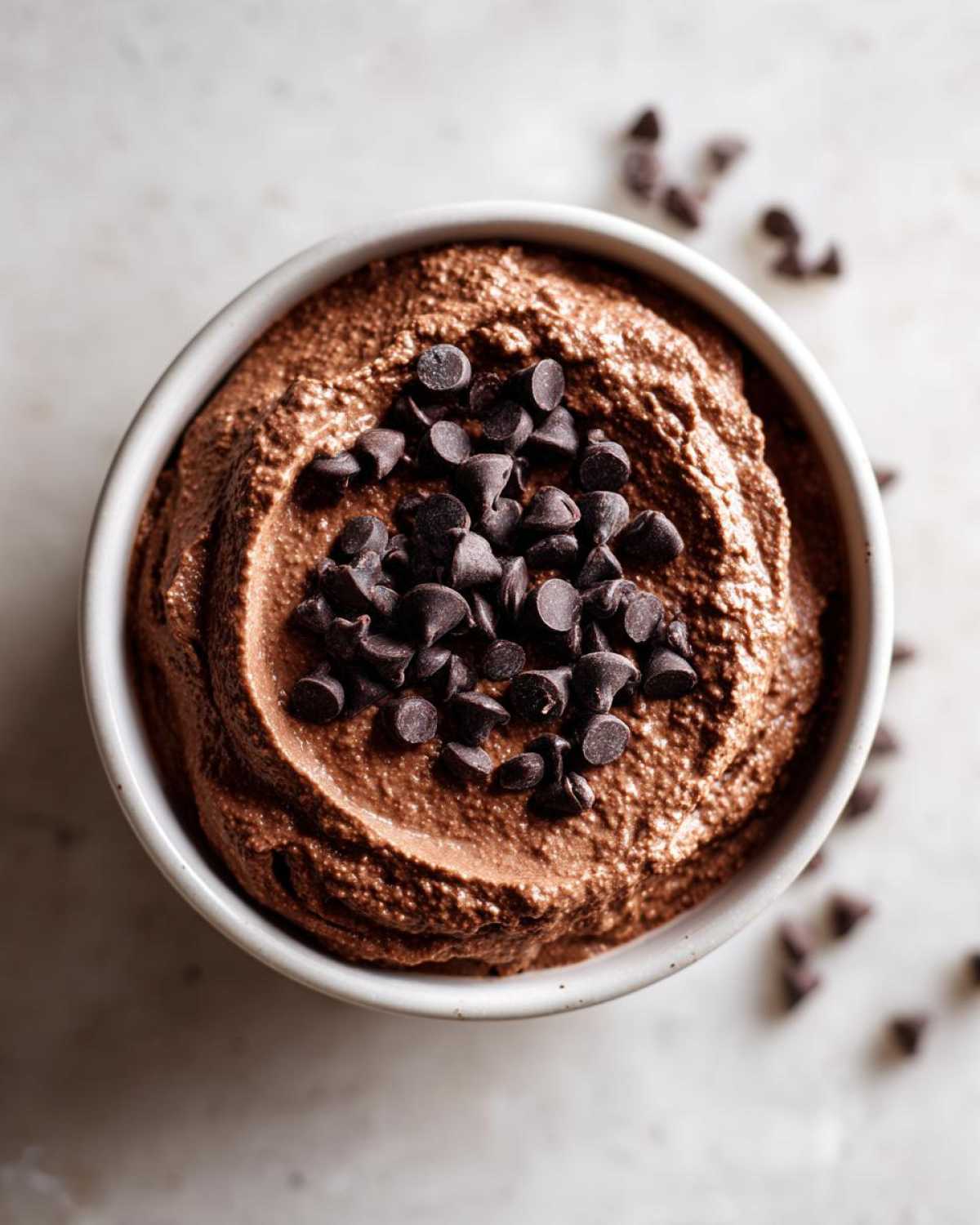 Overhead view of thick, creamy chocolate overnight oats topped generously with dark chocolate chips.