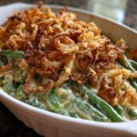 Close-up of a creamy green bean casserole topped generously with crispy fried onions.