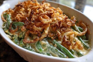 Close-up of a creamy green bean casserole topped generously with crispy fried onions.