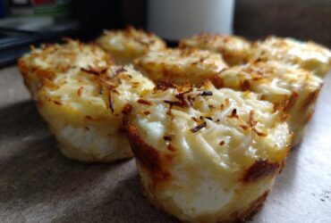 Close-up of freshly baked cottage cheese egg cups starbucks hack, topped with melted and slightly browned cheese.