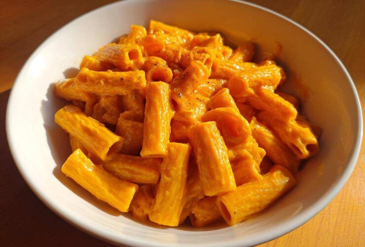 A close-up of creamy butternut squash pasta made with rigatoni, served in a white bowl.