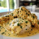 Three pieces of chicken breast smothered in a rich, creamy lemon sauce and sprinkled with fresh parsley.