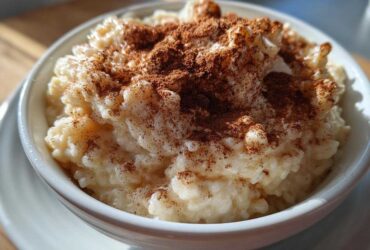 Close-up of a bowl of creamy rice pudding generously sprinkled with ground cinnamon.