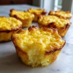 Close-up of a fluffy muffin tin egg bite with a bite removed, showing the texture.