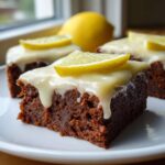 Close-up of a fudgy Lemon Brownies square topped with thick white glaze and a lemon slice.