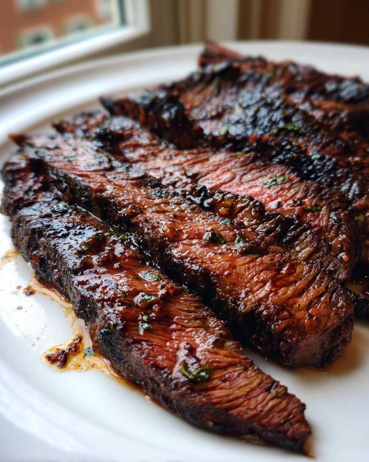 Close-up of perfectly grilled and sliced steak showing a medium-rare interior, coated in the flavorful Carne asada marinade.