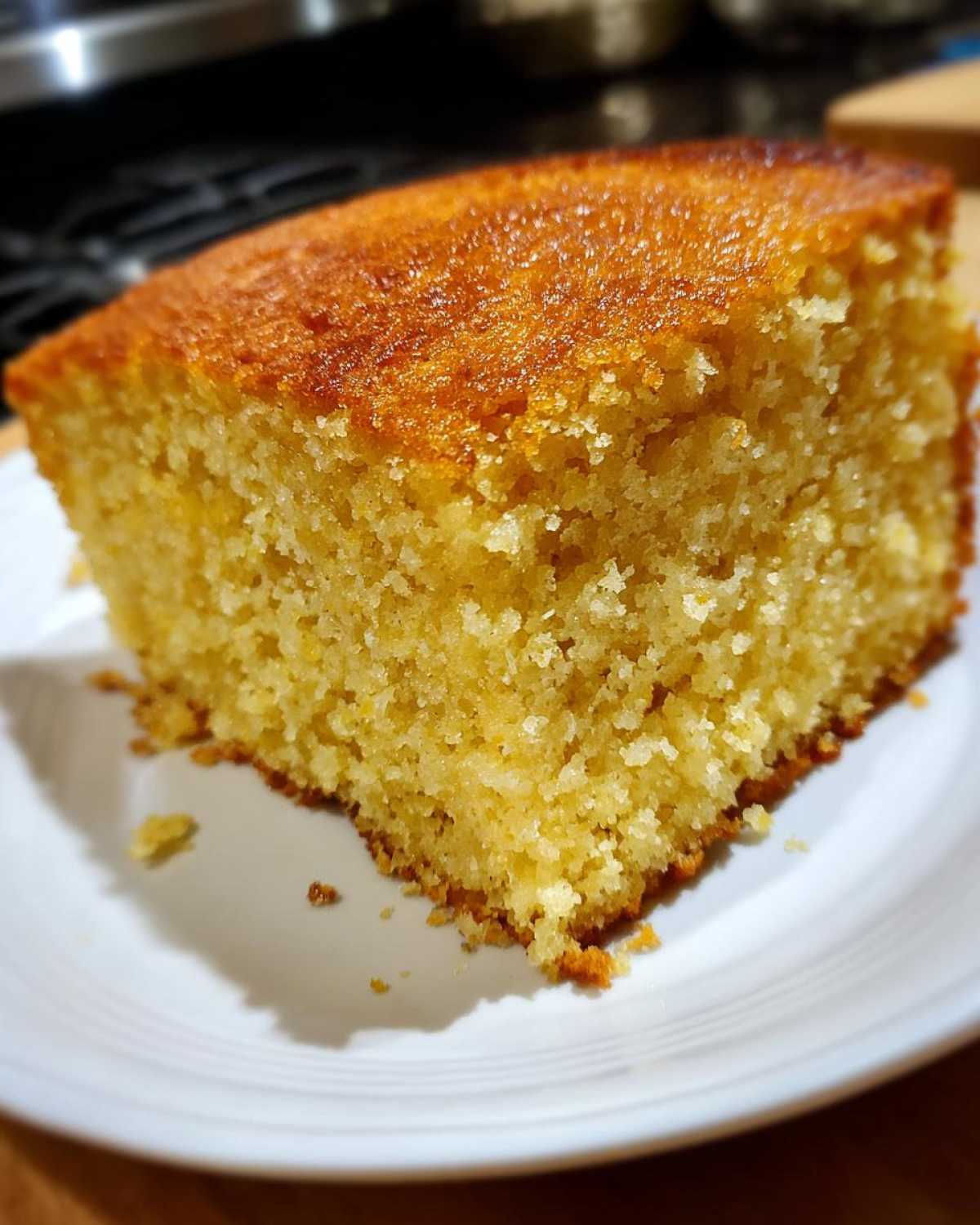Close-up of a thick, moist slice of buttermilk cornbread showing its crumb texture and golden-brown top.