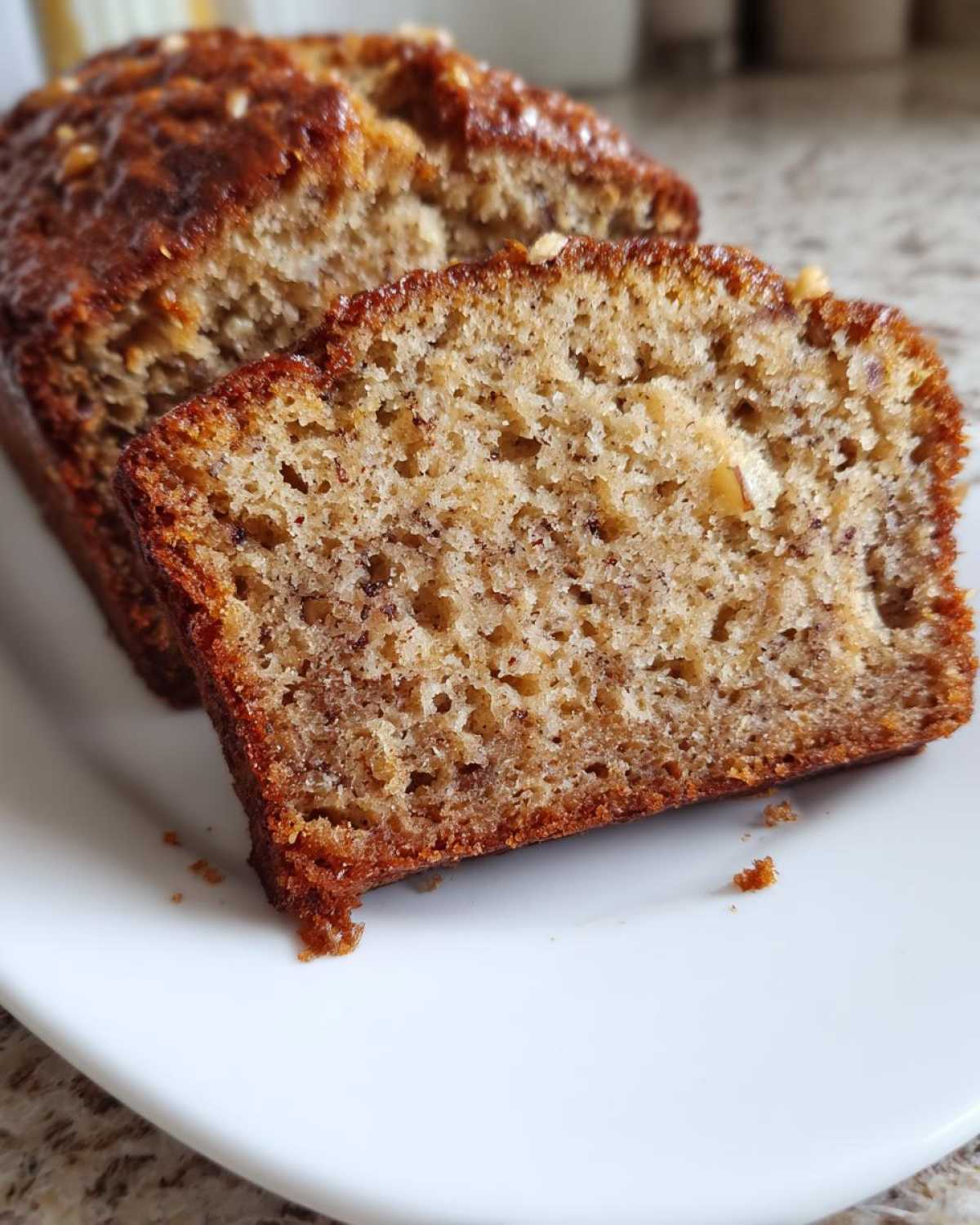Close-up of a moist slice of sugar free banana bread showing its crumb texture and golden-brown crust.
