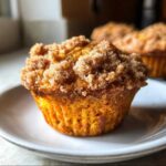 Close-up of a moist sweet potato muffins topped with a thick layer of cinnamon streusel sugar.