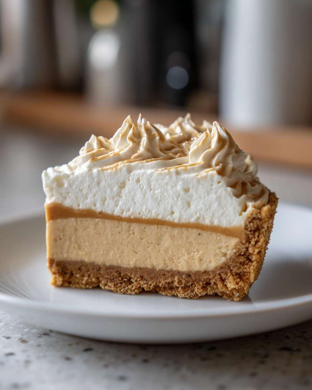 Close-up of a thick slice of no-bake peanut butter pie showing graham cracker crust, creamy filling, and whipped topping.
