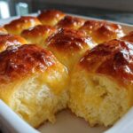 Close-up of a pan of golden brown, shiny glazed dinner rolls with a soft, pull-apart texture.
