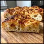 Close-up of a slice showing the airy, open crumb structure of sourdough discard pizza dough.