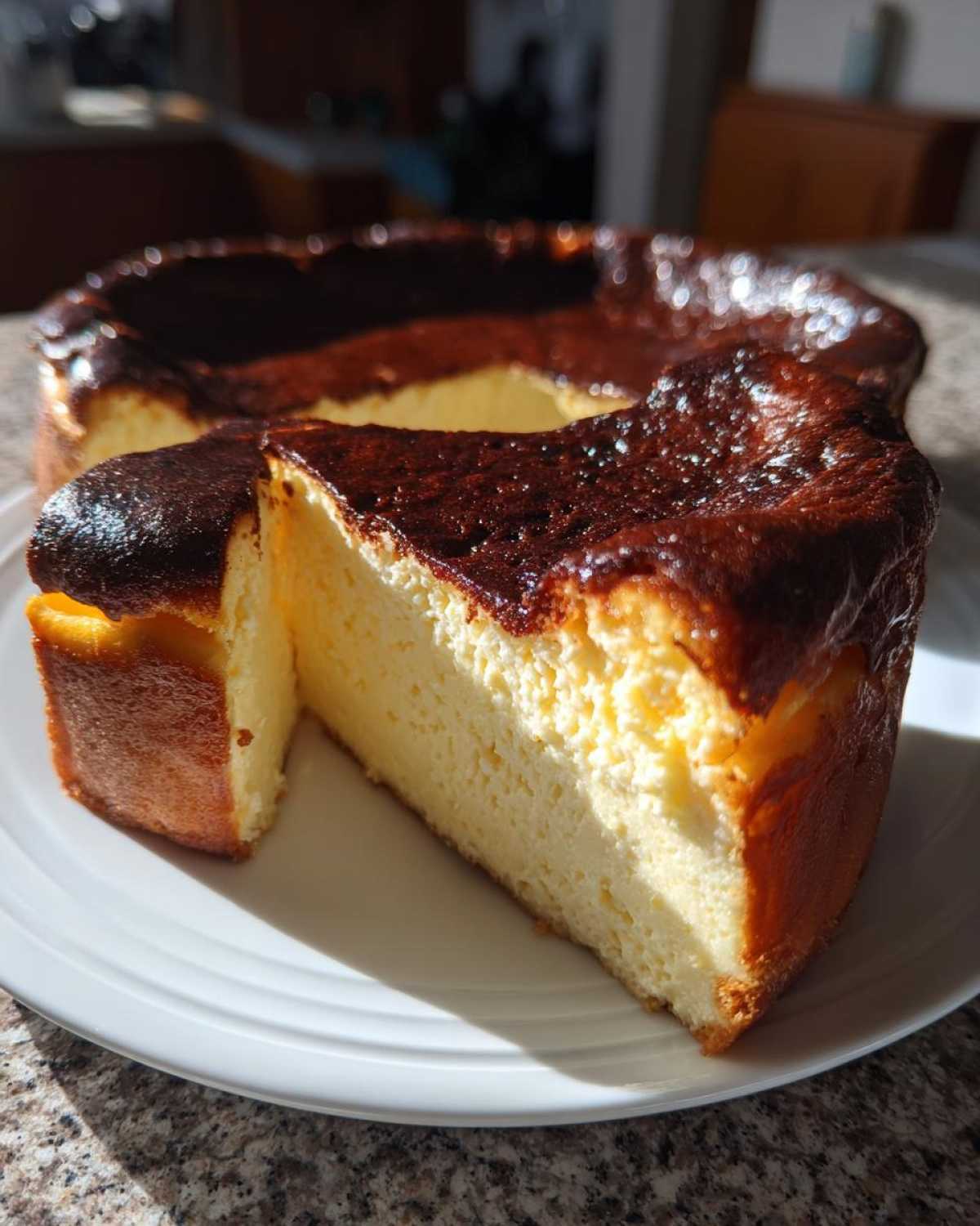 A slice of creamy Basque burnt cheesecake with a deeply caramelized, dark top, sitting on a white plate.