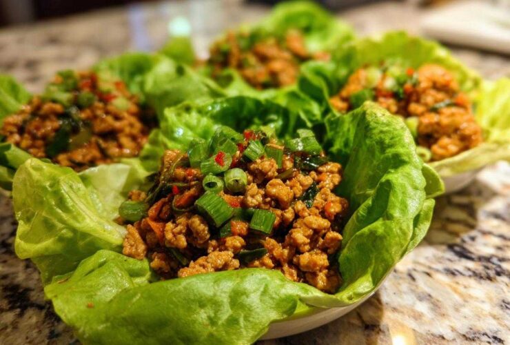 Four servings of flavorful chicken lettuce wraps filled with ground chicken mixture and topped with green onions.