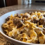 A close-up shot of creamy beef pasta made with egg noodles and seasoned ground beef.
