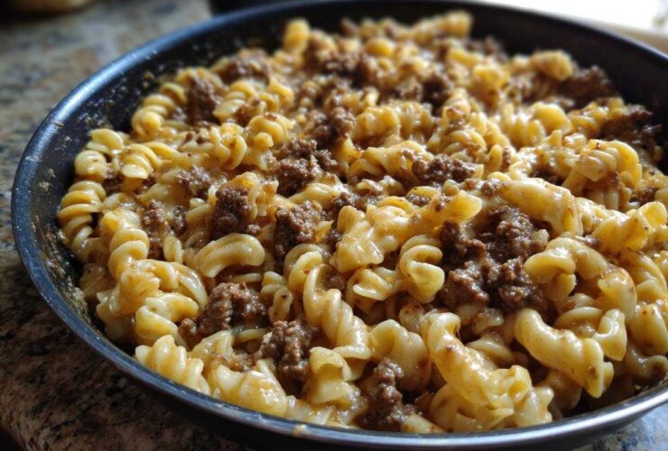 Close-up of creamy beef pasta made with fusilli noodles and ground beef sauce in a black skillet.