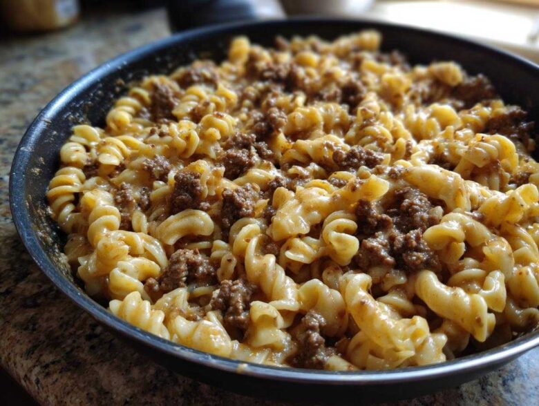 Close-up of creamy beef pasta made with fusilli noodles and ground beef sauce in a black skillet.