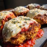 Close-up of a crispy keto chicken parmesan cutlet smothered in marinara sauce and melted mozzarella cheese.