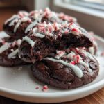 Close-up of rich double chocolate peppermint cookies drizzled with white icing and topped with crushed candy canes.