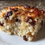 A close-up of a square serving of french onion butter rice, showing creamy rice grains and a deeply caramelized, cheesy top layer.