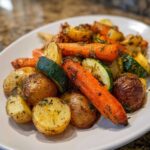 A close-up of perfectly roasted carrots, potatoes, and zucchini seasoned with herbs, showcasing the amazing Garlic Herb Roasted Veggies.