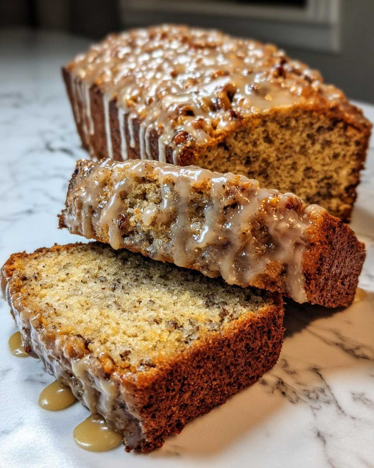 Close-up of two slices of sweet alabama pecan bread with a thick, dripping pecan glaze.