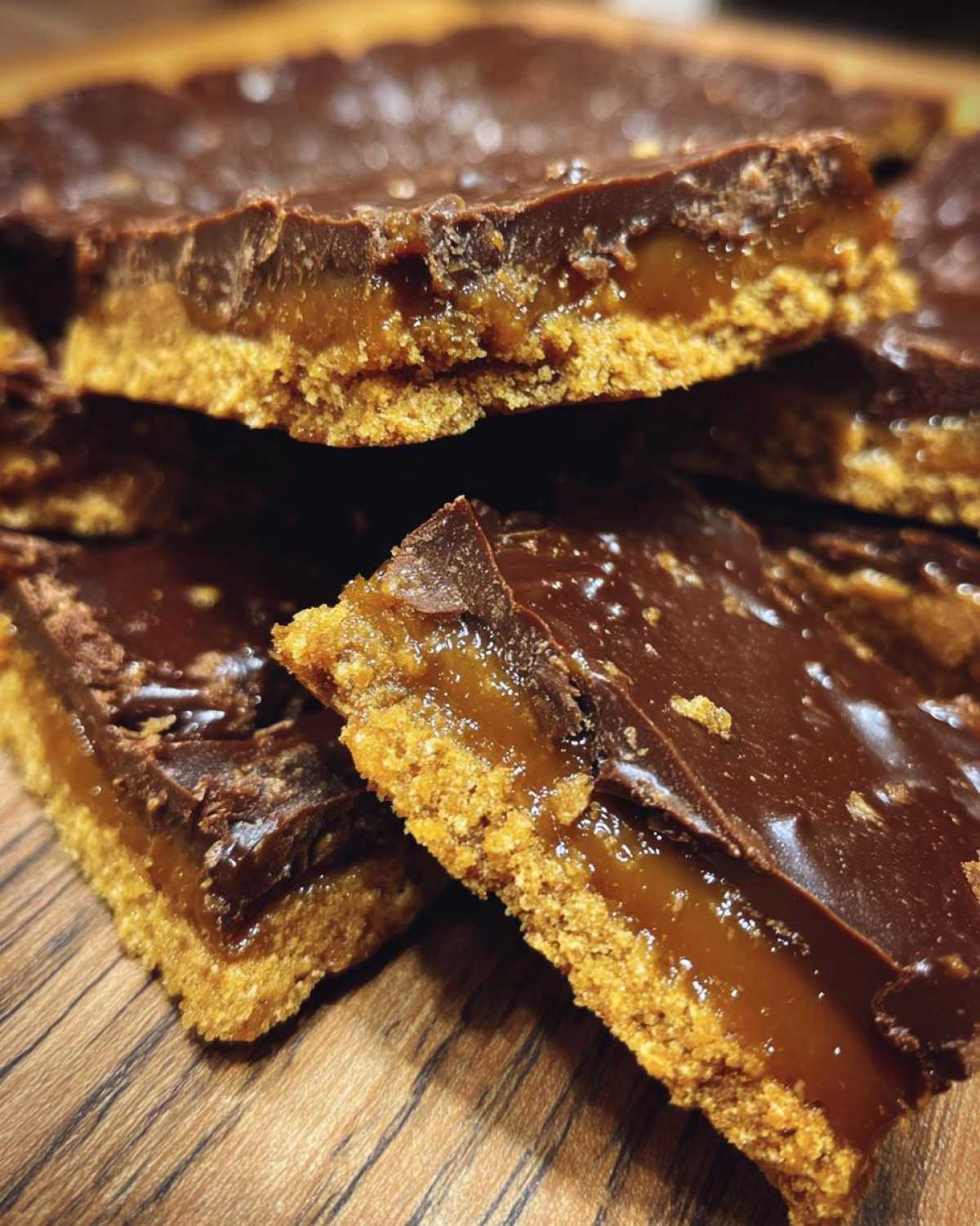 Close-up of stacked graham cracker toffee bars showing the crunchy base, gooey caramel layer, and chocolate topping.
