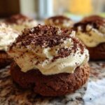 A close-up of one delicious tiramisu cookies featuring a dark chocolate base topped with whipped cream and cocoa powder.