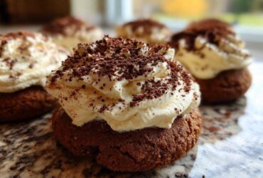 A close-up of one delicious tiramisu cookies featuring a dark chocolate base topped with whipped cream and cocoa powder.