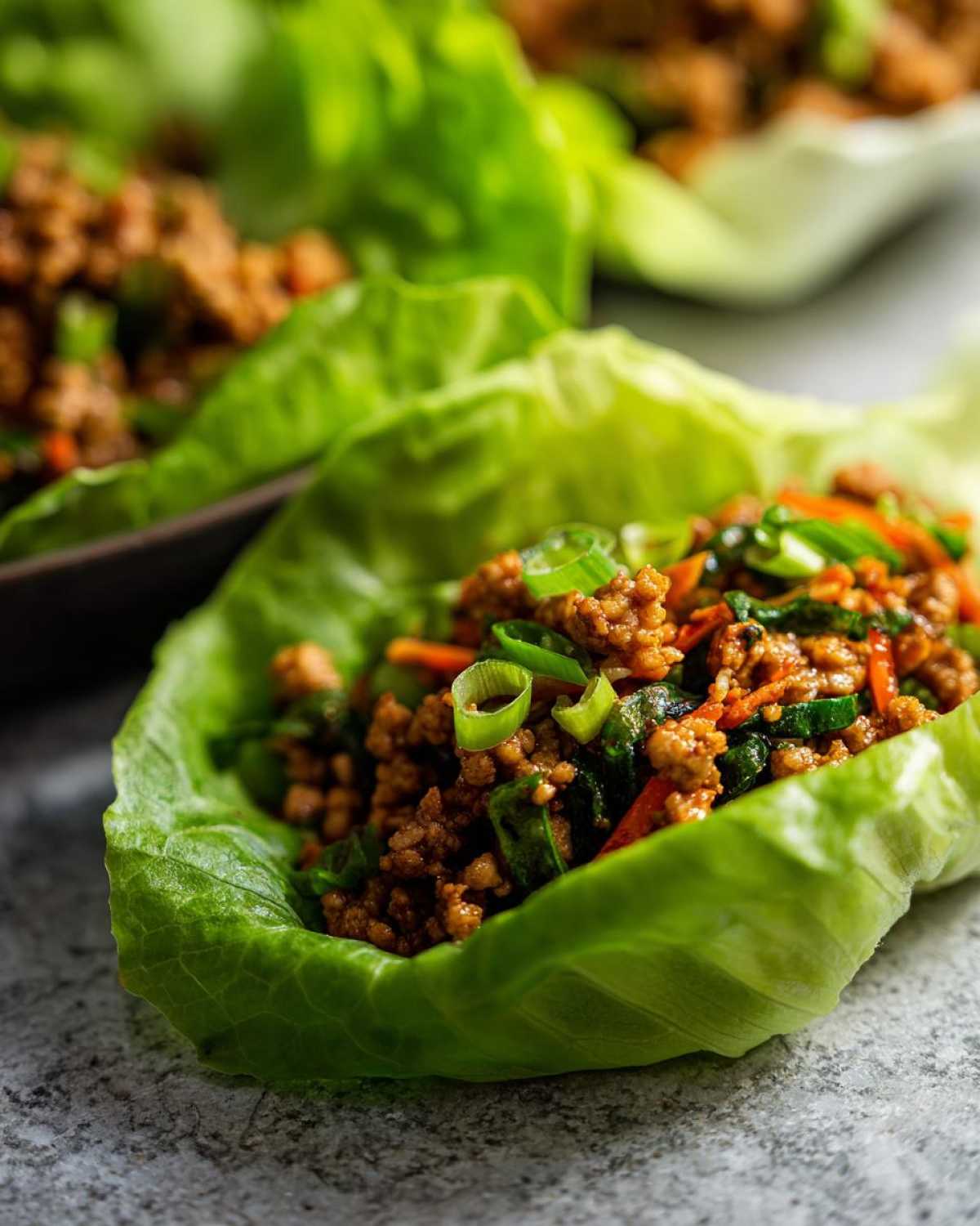 Close-up of a fresh lettuce cup filled with savory ground chicken mixture for chicken lettuce wraps.