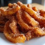 A close-up of Air Fryer Crispy Cinnamon Sugar Banana Chips piled on a white plate.