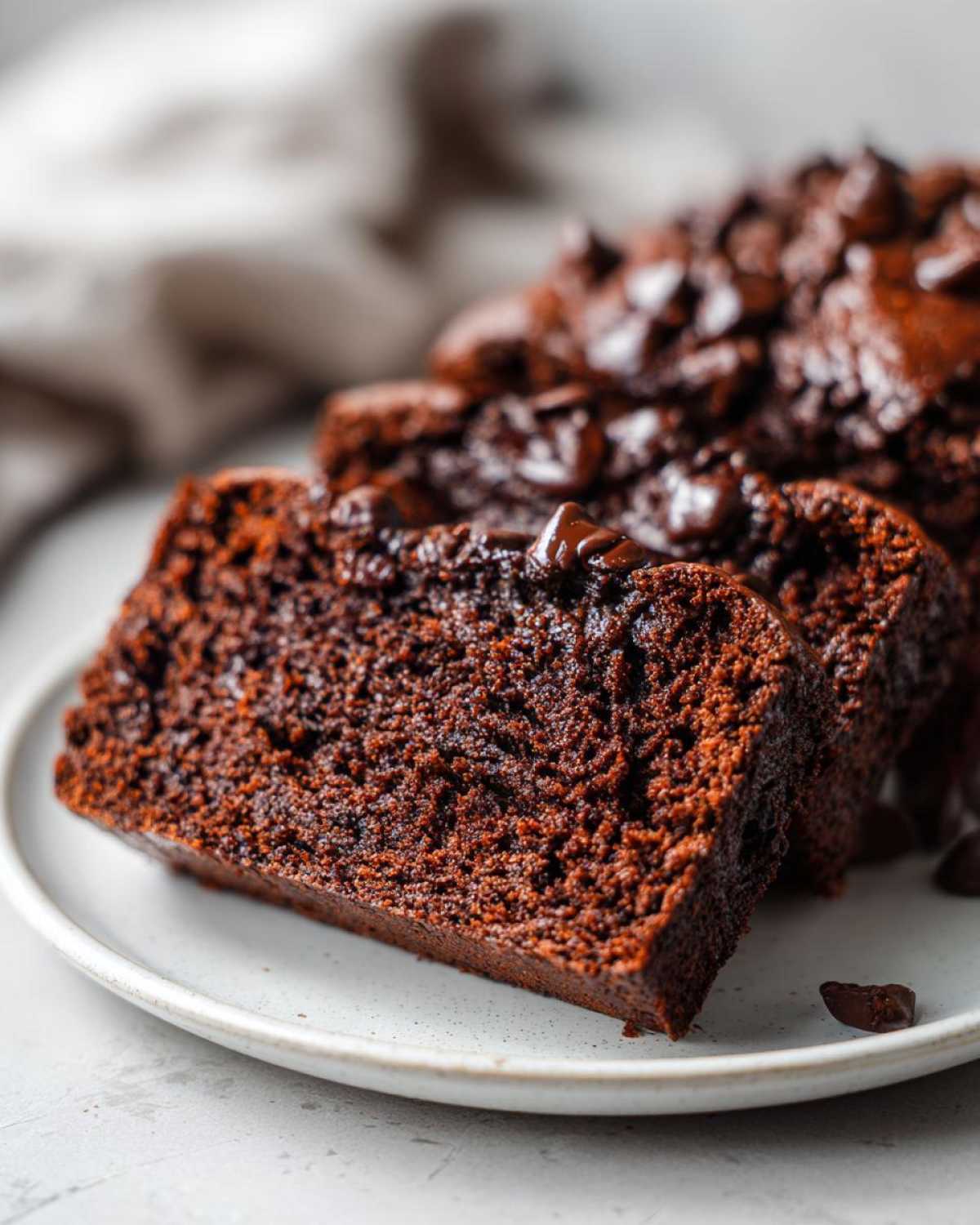 Close-up of moist slices of rich Gluten-Free Chocolate Zucchini Bread topped with melted chocolate chips.
