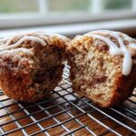 Close-up of Gluten-Free Cinnamon Roll Muffins cut in half showing cinnamon swirl and icing.