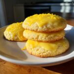 Three stacked Gluten-Free Lemon Sugar Cookies topped with bright yellow glaze and lemon zest.
