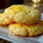 Three stacked Gluten-Free Lemon Sugar Cookies topped with a bright yellow glaze and fresh lemon zest.