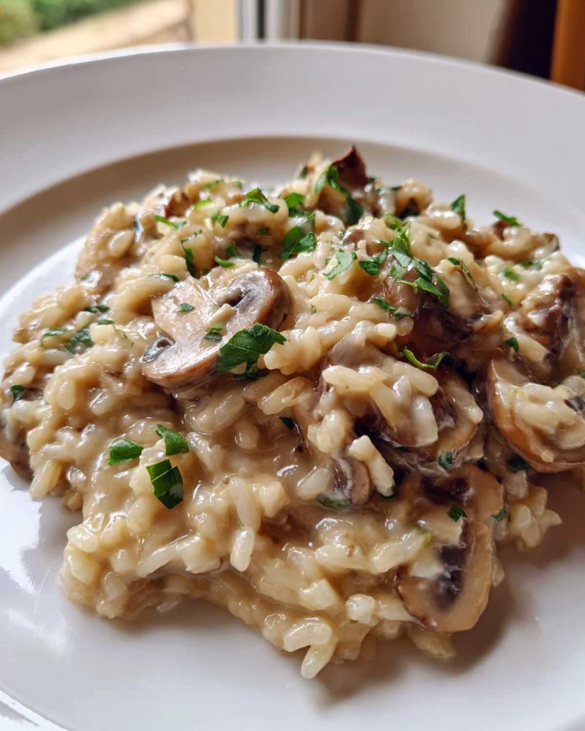 Close-up of creamy Instant Pot Creamy Mushroom Risotto topped with sliced mushrooms and fresh parsley.