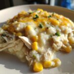 A close-up of a creamy serving of Instant Pot White Chicken Chili with Corn topped with melted cheddar cheese.