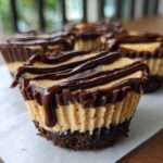 A close-up of a No-Bake Chocolate Peanut Butter Cheesecake Cup with a chocolate drizzle.
