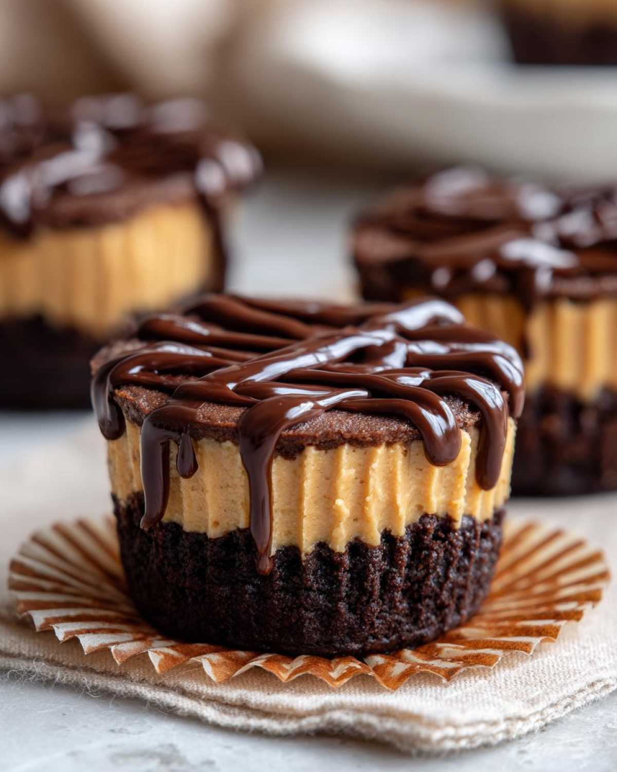 A close-up of a No-Bake Chocolate Peanut Butter Cheesecake Cup with a rich chocolate drizzle.