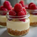 Close-up of a No-Bake Raspberry White Chocolate Cheesecake Jar topped with fresh raspberries.