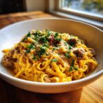 A close-up of One-Pot Creamy Garlic Butter Beef and Noodles in a white bowl, topped with parsley.