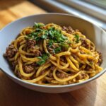 A bowl of One-Pot Creamy Garlic Butter Beef and Noodles topped with fresh parsley.