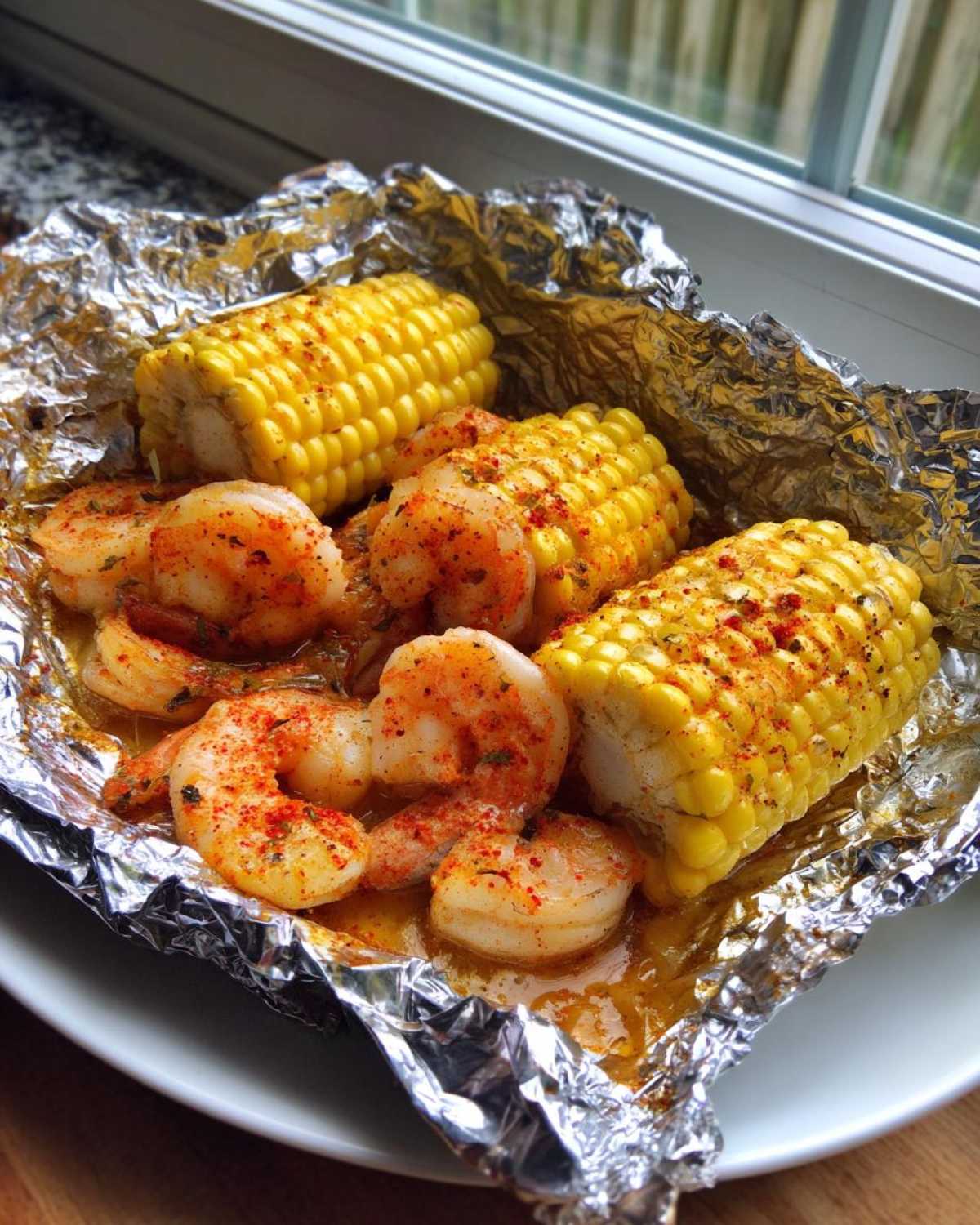 Cooked shrimp and corn on the cob served in an opened foil packet, seasoned with Cajun spices.