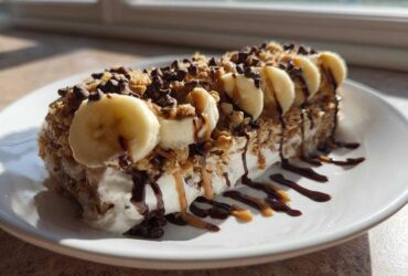 Thick Vegan Chocolate Peanut Butter Banana Smoothie Bowl topped with banana slices, granola, and chocolate drizzle.