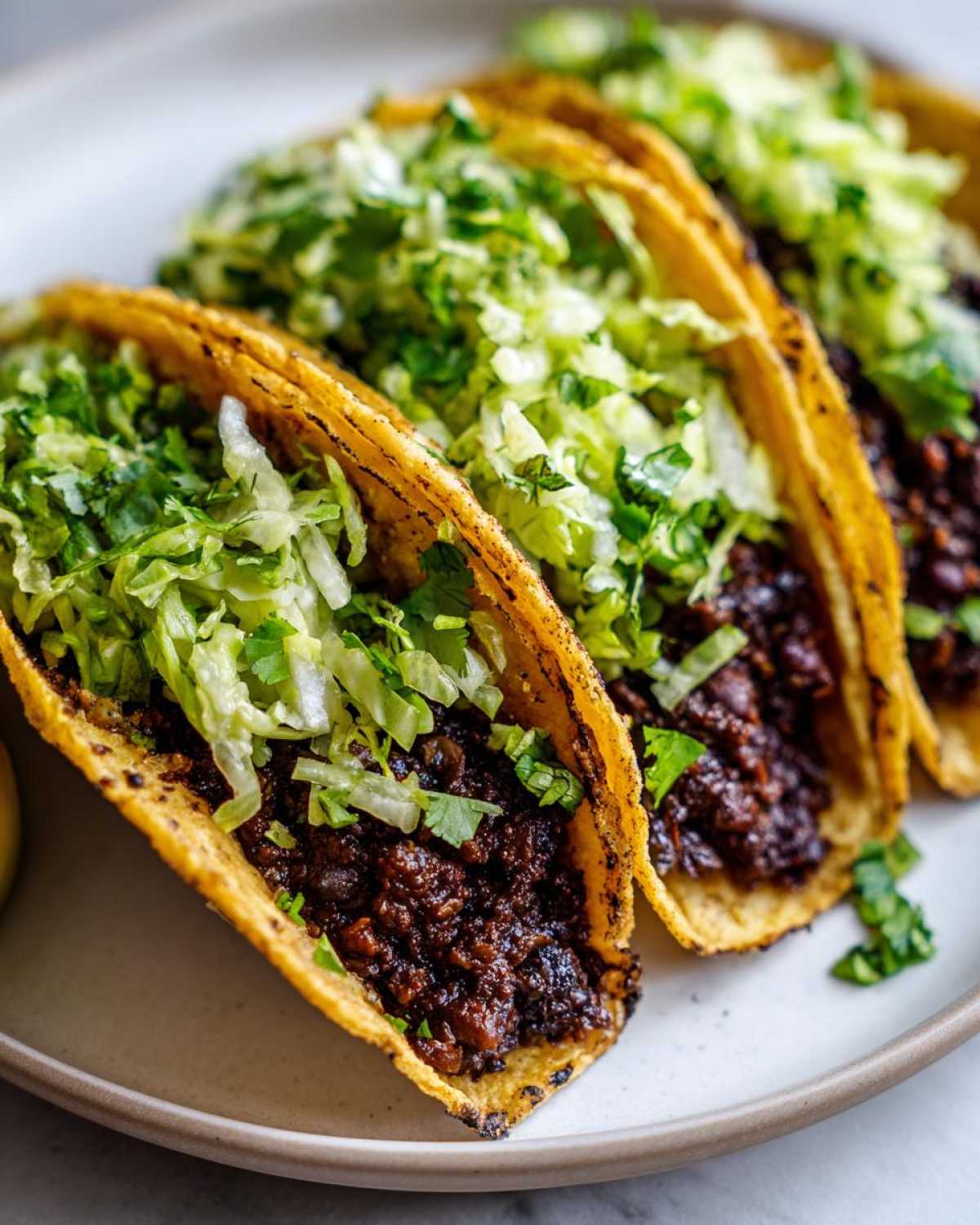 Three crispy tacos filled with rich black bean mixture and topped generously with bright cilantro lime slaw.