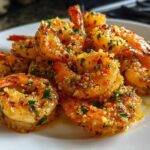 Close-up of a pile of Air Fryer Crispy Garlic Butter Shrimp coated in garlic, butter, and parsley.